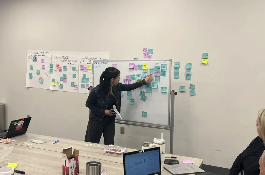 Facilitating a strategic planning workshop, sorting sticky notes on a whiteboard