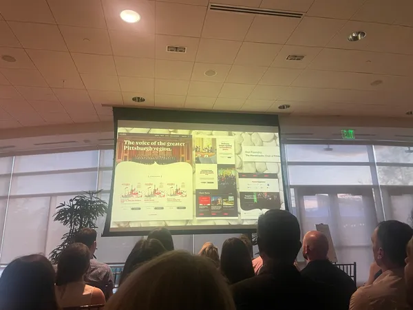 An audience watching a presentation screen showing the final Mendelssohn Choir website design