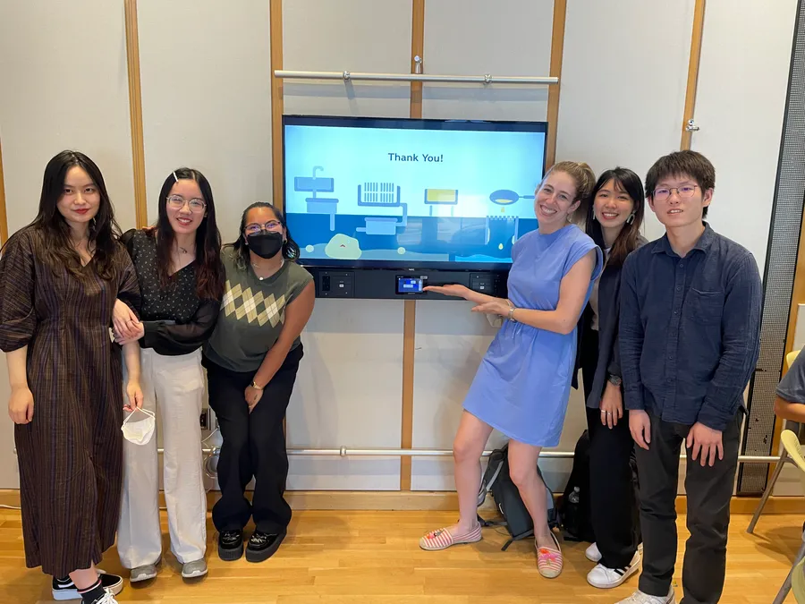 Team standing in front of a screen displaying a 'Thank You' slide at the final presentation
